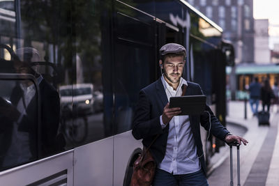 Young man using mobile phone in city