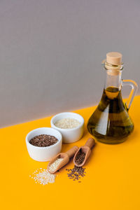 Sesame and flax seeds wooden spoons with oil in glass bottle. healthy food concept. vegan keto diet.