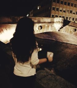 Woman with arms outstretched at night