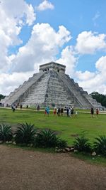 Tourists vising historical building against sky