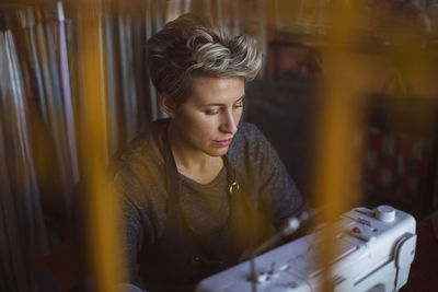 Female fashion designer using sewing machine in design studio