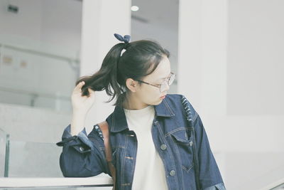 Young woman standing against wall