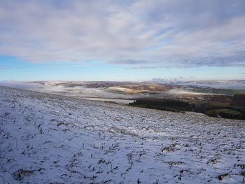 Scenic view of snow covered land against sky
