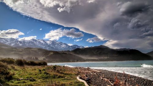 Scenic view of sea and mountains against sky