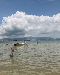 Man surfing in sea against sky