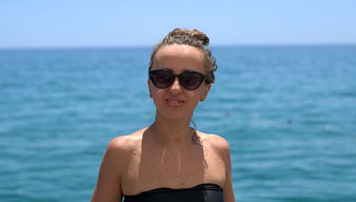 Portrait of smiling mid adult woman against sea