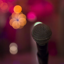 Close-up of microphone against illuminated lights