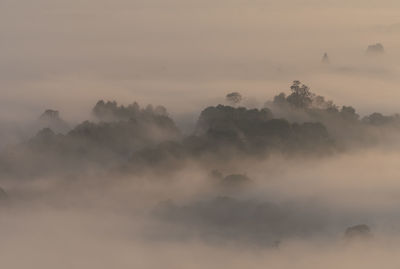 Scenic view of fog against sky at sunset