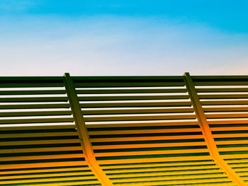 Wooden sun lounger at the beach or on a cruise ship against sunny blue sky.