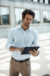 Businessman using tablet pc on sunny day