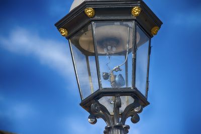 Close-up of gas light against blue sky