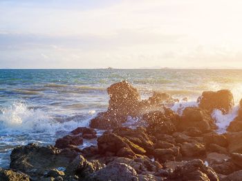 Scenic view of rocks in sea against sky