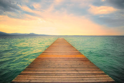 Pier over sea against sky during sunset