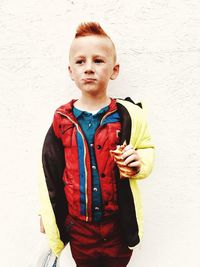 Portrait of boy standing against wall