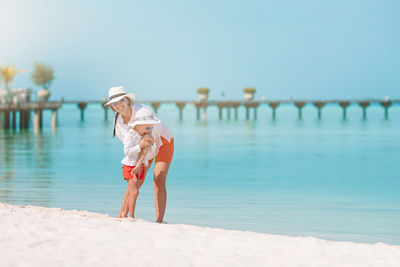 Full length of woman on beach against sky