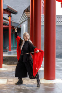Portrait of young woman standing in city