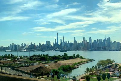 Scenic view of river by buildings against sky