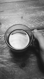Close-up of hand holding drink on table