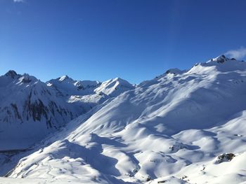 Scenic view of snowcapped mountains against clear blue sky