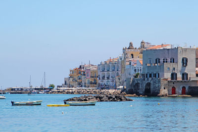 Boats in river with buildings in background