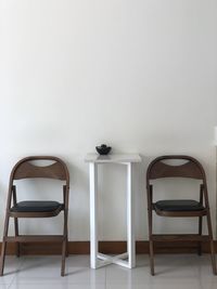 Empty chairs and table against wall at home