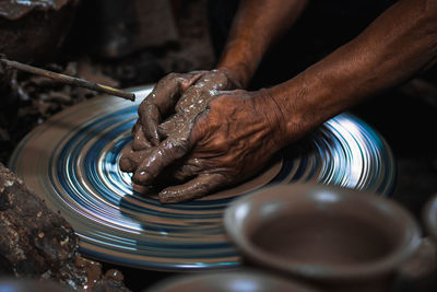 Cropped hands of man making pottery in workshop