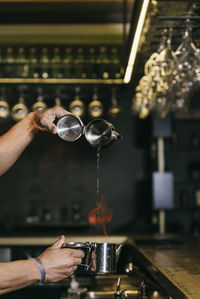 Close-up of hand pouring water in glass