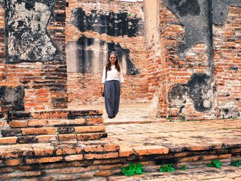 Woman standing against brick wall