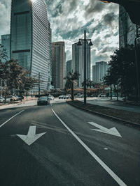 View of city street against cloudy sky