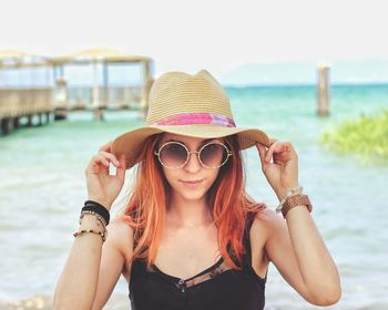 Portrait of young woman wearing sunglasses on beach