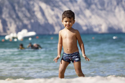 Shirtless man swimming in sea