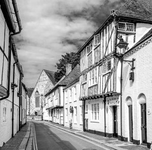 Empty road amidst buildings against sky