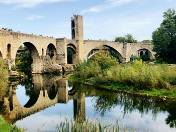 Arch bridge over river against sky