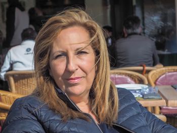 Close-up portrait of woman sitting at outdoor cafe