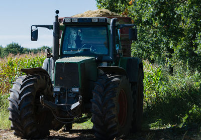 Tractor on field against trees