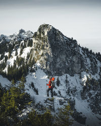 Person standing on snowcapped mountain against sky