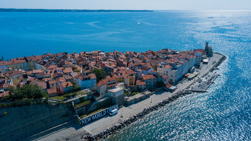 High angle view of buildings by sea against sky