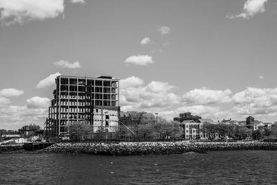 Built structure by water against sky