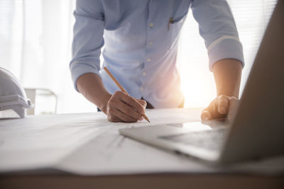 Midsection of man working on table