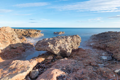 Rocks in sea against sky