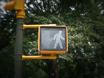 Low angle view of road sign against trees