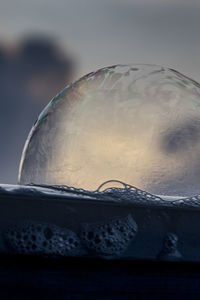 Close-up of bubbles in puddle against sky