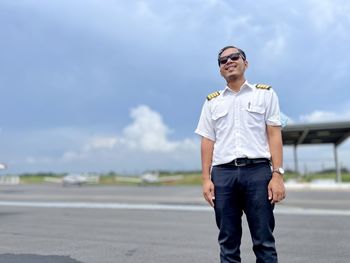 Young man wearing sunglasses standing against sky