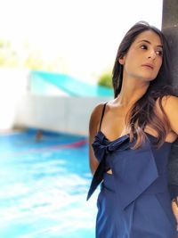 Portrait of young woman standing in swimming pool