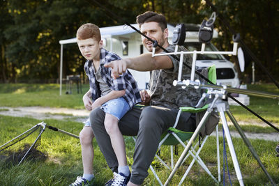 Father and son sitting outdoors