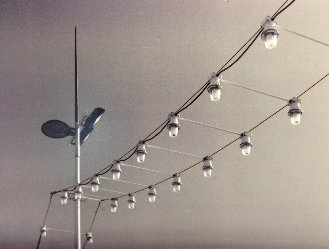 low angle view, lighting equipment, electricity, hanging, illuminated, electric light, street light, in a row, sky, connection, light bulb, cable, decoration, clear sky, no people, ceiling, technology, close-up, light - natural phenomenon, night