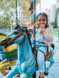 Portrait of a girl with carousel in amusement park