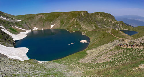 Scenic view of lake and mountains against blue sky