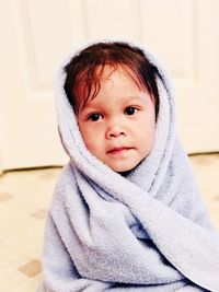 Portrait of cute girl wrapped in towel at home