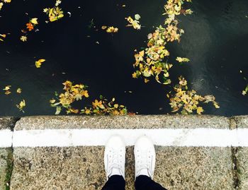 Low section of person standing on floor against sky